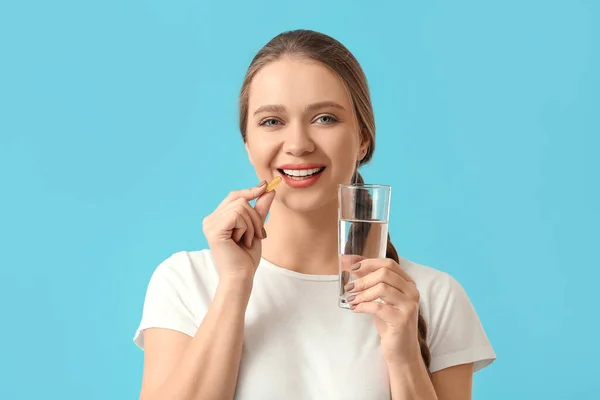 Mujer Joven Tomando Aceite Pescado Sobre Fondo Color —  Fotos de Stock