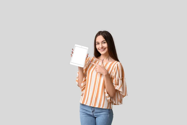 Mladá Žena Ukazuje Tablet Počítače Světlém Pozadí — Stock fotografie