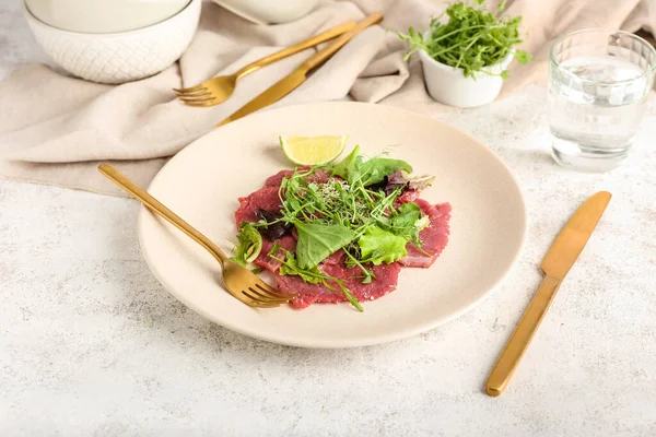 Plate Tasty Veal Carpaccio Glass Water Fresh Sprouts Light Background — Stock Photo, Image