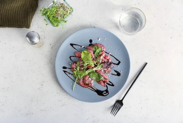 Plate Tasty Veal Carpaccio Glass Water Fresh Sprouts Light Background — Stock Photo, Image