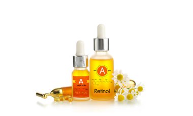 A vitamini şişeleri ve beyaz arka planda haplar