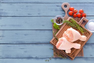 Tahtada çiğ tavuk bacağı ve ahşap kaplama var.