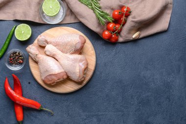 Koyu arka planda çiğ tavuk bacaklı tahta