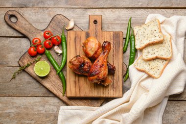 Ahşap zemin üzerinde kızarmış tavuk bacağı olan tahta.