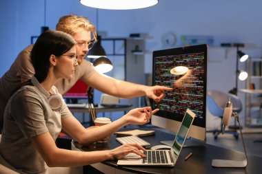 Geceleri bilgisayarla çalışan genç programcılar