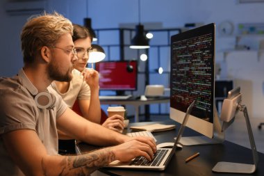 Geceleri bilgisayarla çalışan genç programcılar