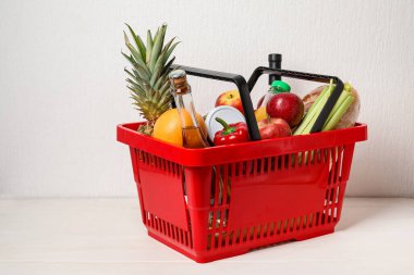 Beyaz arka planda yiyecek olan alışveriş sepeti.