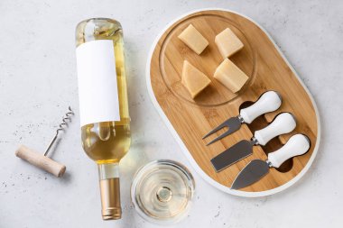 Bir şişe nefis şarap, üzerinde peynir ve cam olan bir yemek.