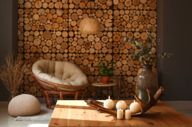 Oturma odasındaki masada mum ve vazo yakan geyik boynuzu.