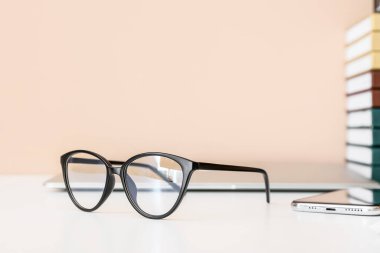 Renkli duvarın yanındaki masada şık gözlükler, yakın plan.