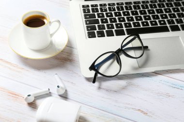 Gözlüklü kompozisyon ve açık ahşap arka planda bir fincan kahve.