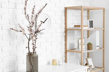 Odanın içinde çiçek açan bahar dalları olan vazo