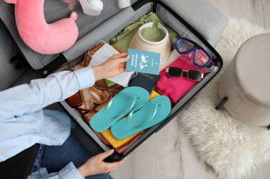 Evde bavul hazırlayan bir kadın.