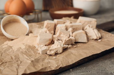 Ahşap tahta tahta, arka planda taze ve kuru maya var.