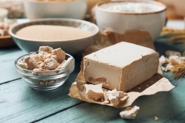 Renkli ahşap arka planda taze ve kuru mayalı kaseler