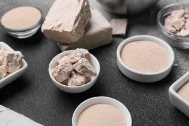 Koyu arkaplanda taze ve kuru maya olan kaseler.