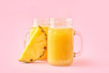 Renkli arkaplanda Mason kavanozları dolusu lezzetli ananas suyu.