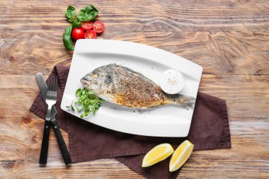 Ahşap arka planda kızarmış Dorado tabağı.