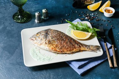 Renkli arkaplanda kızarmış dorado tabağı