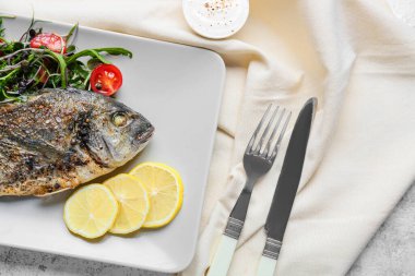 Kızarmış dorado ve hafif arkaplanlı salata.