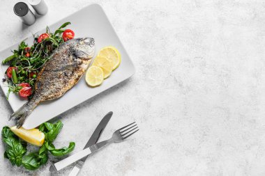 Kızarmış dorado ve hafif arkaplanlı salata.