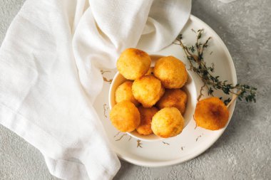 Arka planda kızarmış patates topları olan bir kase.