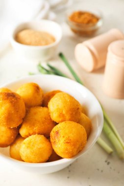 Hafif arka planda kızarmış patates topları olan bir kase.