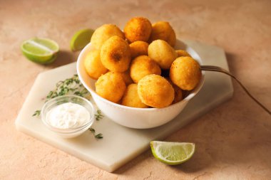 Kızarmış patates topları ve soslu bir kase.