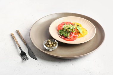 Lezzetli domates carpaccio tabağı ve hafif arka planda kapari.