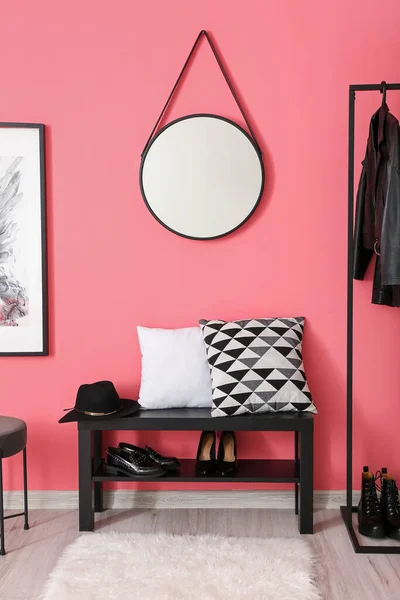 Interior of stylish hallway with shoes stand