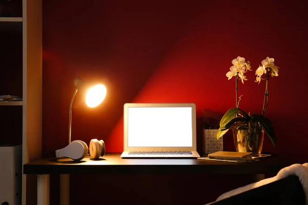 Modern Arbetsplats Med Laptop Och Glödande Lampa Nära Färg Vägg — Stockfoto