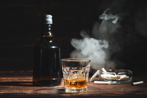 Flaska Och Glas Kall Whisky Cigaretter Träbord Mot Mörk Bakgrund — Stockfoto