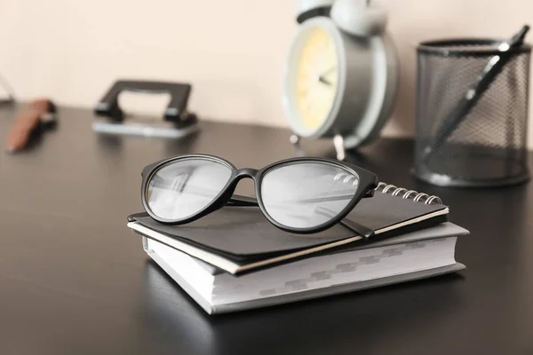 テーブルの上にノートが置かれたスタイリッシュなメガネ クローズアップ — ストック写真