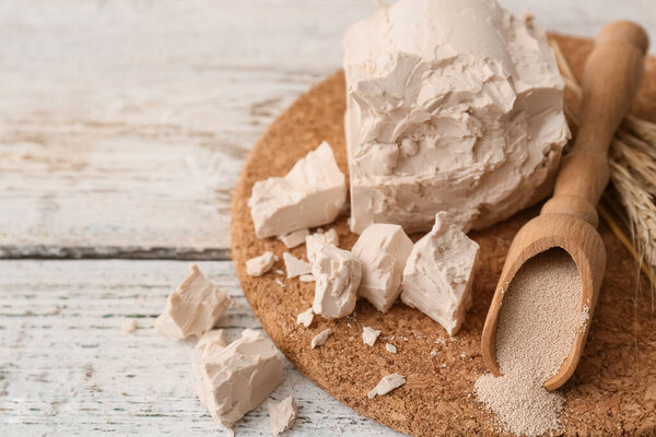 Доска со свежими и сухими дрожжами на светлом деревянном фоне