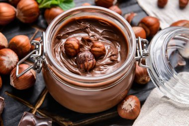 Lezzetli çikolata ezmeli kavanoz ve koyu fındıklı, yakın plan.