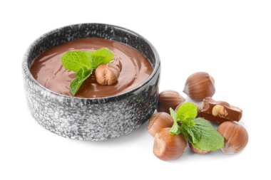 Lezzetli çikolata ezmeli kase ve beyaz arka planda fındık.