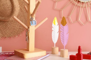 Holder with keys and decor on shelf near color wall