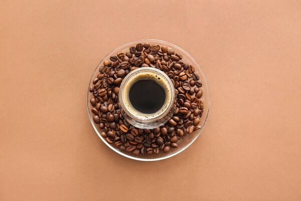 Cup of turkish coffee and saucer with beans on color background