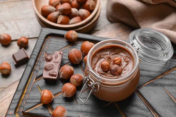 Jar Tasty Chocolate Paste Hazelnuts Wooden Background — Stock Photo, Image