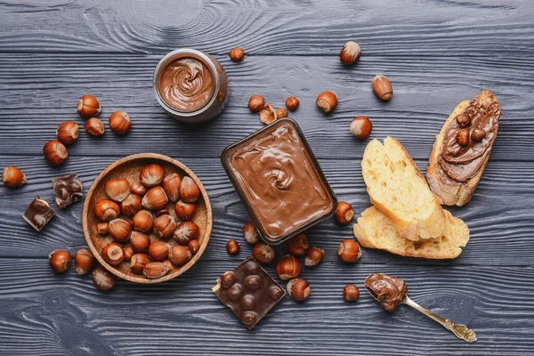 Composition Tasty Chocolate Paste Hazelnuts Dark Wooden Background — Stock Photo, Image