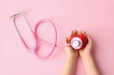 Kırmızı kalpli ve steteskoplu çocuk elleri