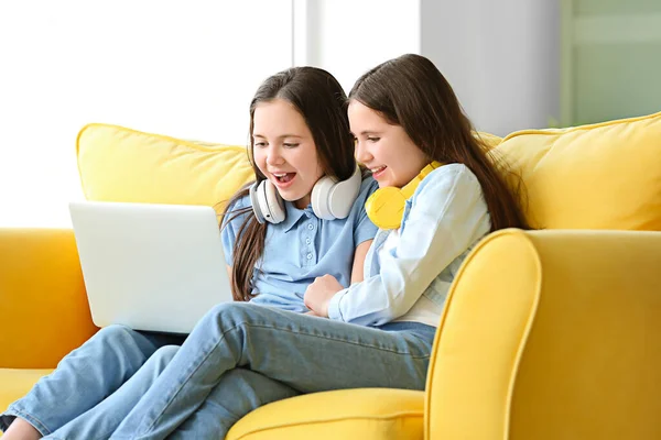 Cute twin girls watching cartoons at home