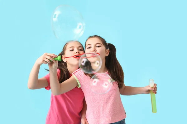 Cute Twin Girls Blowing Soap Bubbles Color Background — Stock Photo, Image