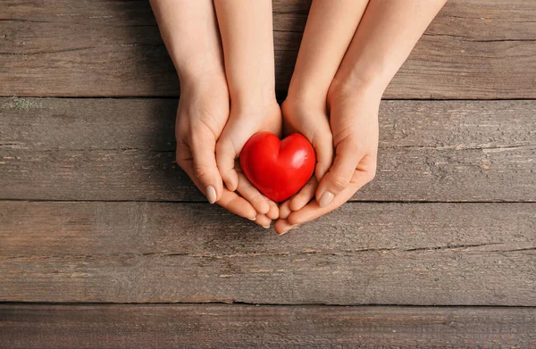 Mãos Mulher Criança Com Coração Vermelho Fundo Madeira — Fotografia de Stock