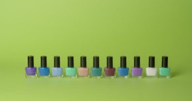 Different nail polishes on color background, video with stop motion effect