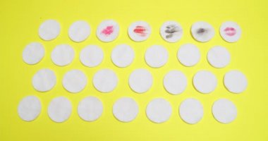 Many cotton pads on color background, video with stop motion effect