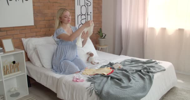 Belle Jeune Femme Enceinte Avec Des Vêtements Bébé Dans Chambre — Video