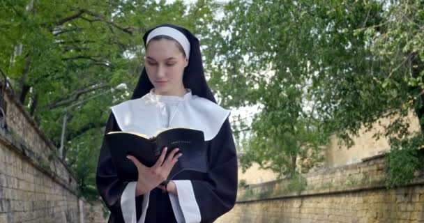 Young Nun Reading Bible Outdoors — Stock Video