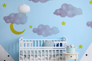 Interior of modern children's room with comfortable bed and beautiful painting on wall