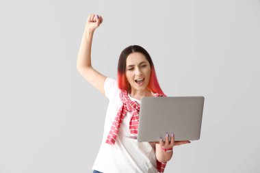 Işık arka planında dizüstü bilgisayar kullanan mutlu kadın programcı